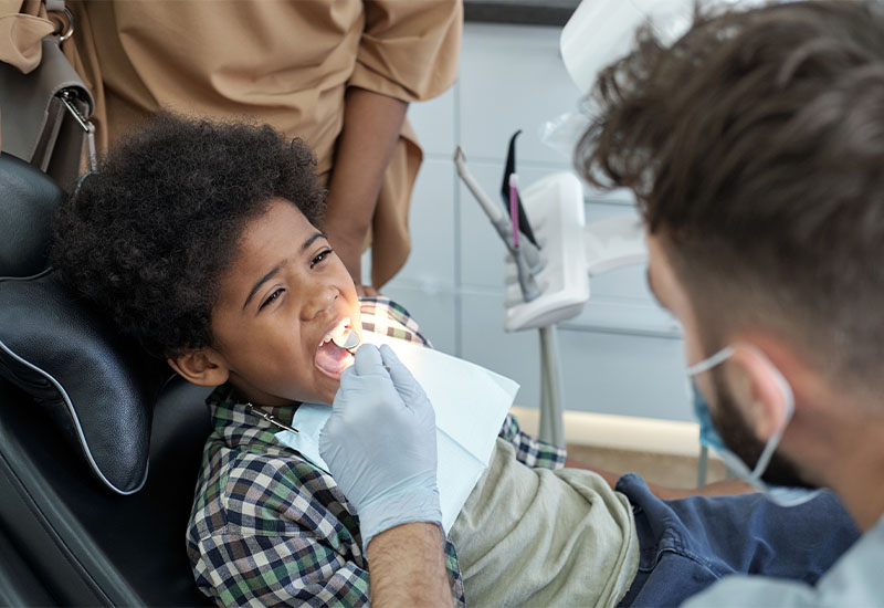 A child sitting in a dental chair during a checkup