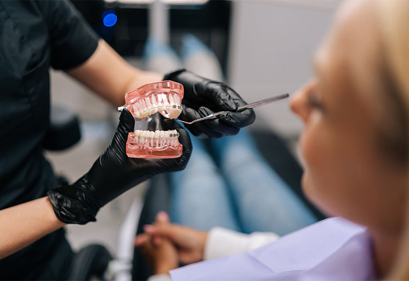 A dentist working chairside beside a reclined patient