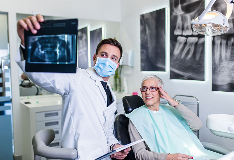 A dentist and patient reviewing a dental scan together on a screen